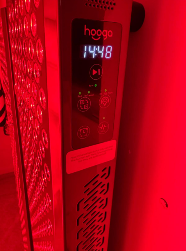 Red light therapy session in progress with panel illuminating
